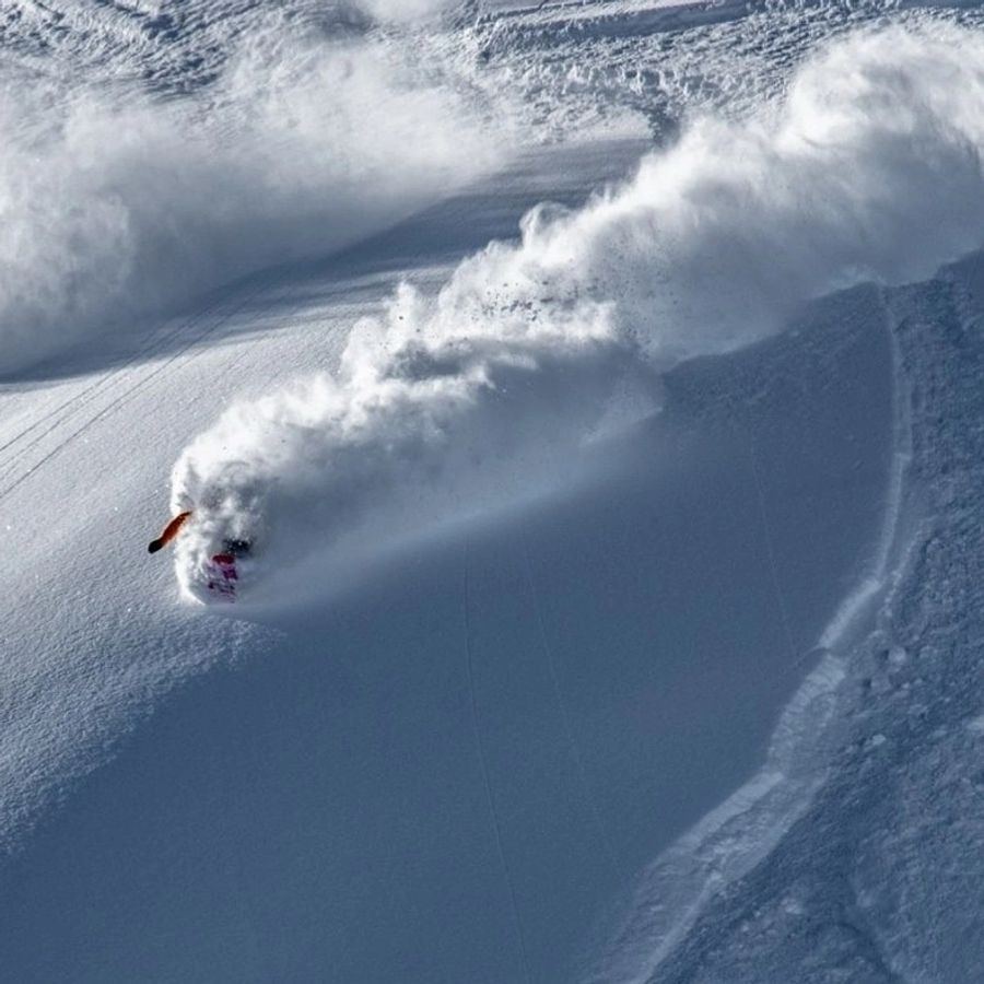 SMG heli ski guide standing on a ridge in the Northern Chugach
